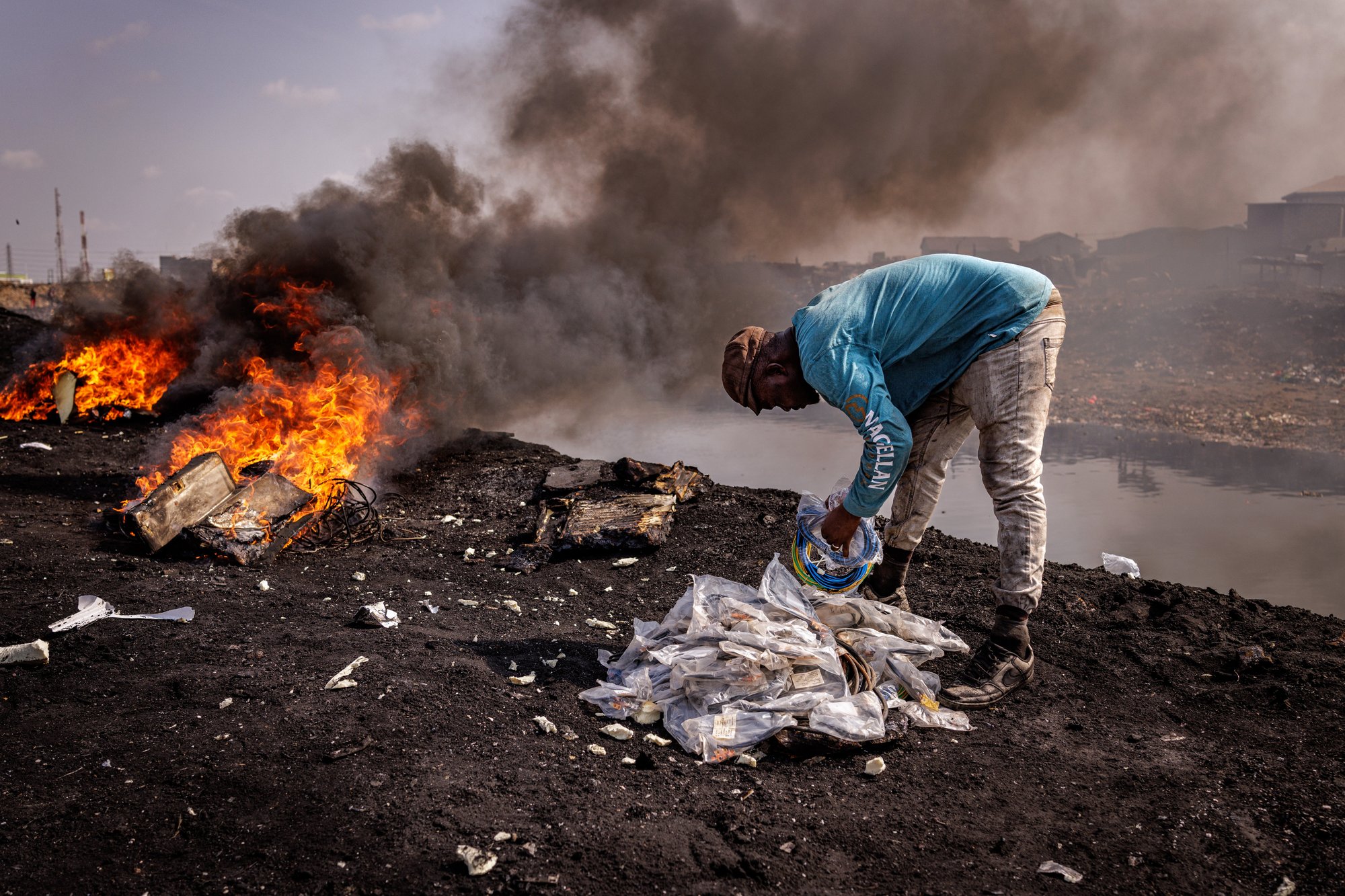 Worker carrying wire still in original Chinese packaging to the burn site