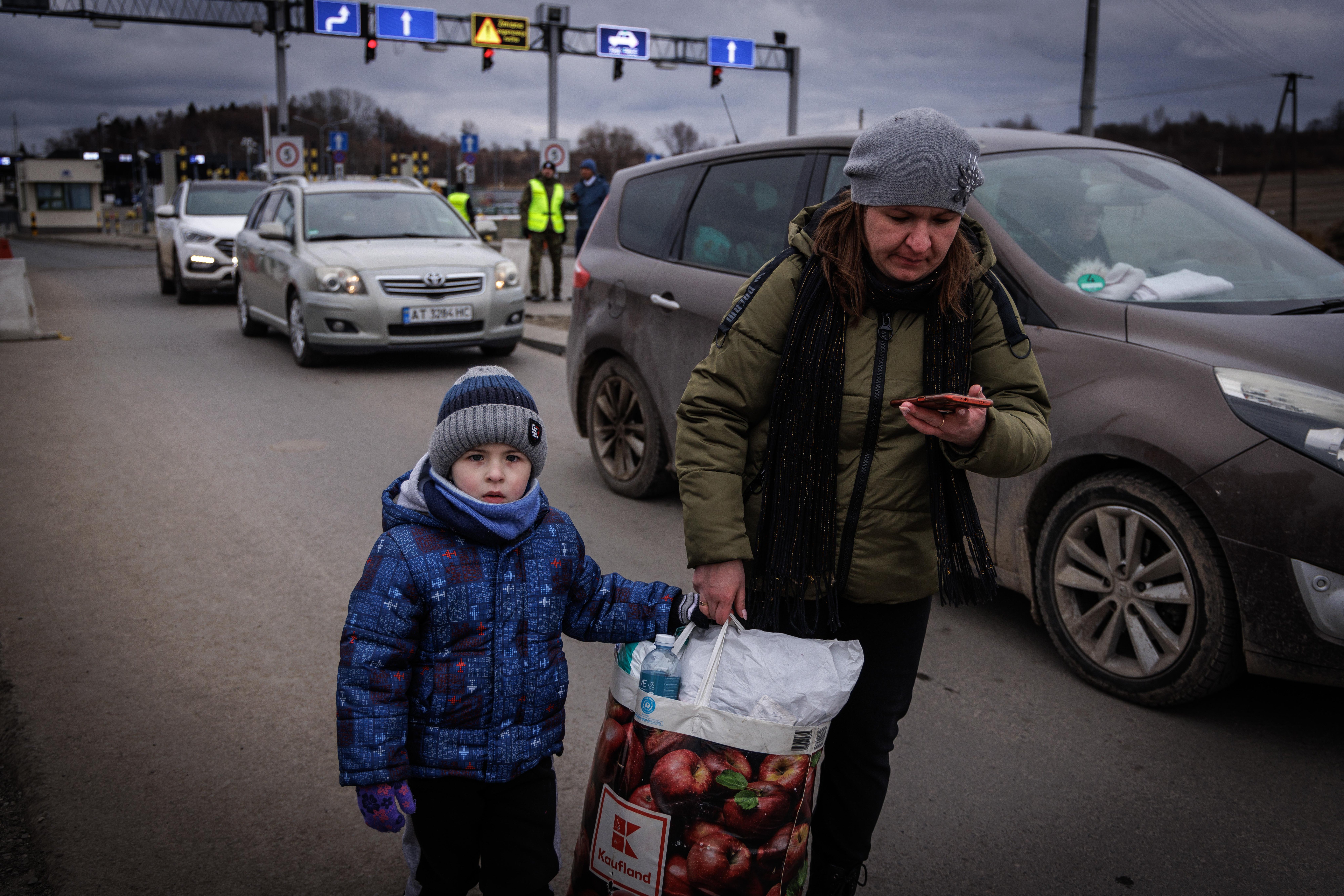 Boy and mother with bags at border crossing